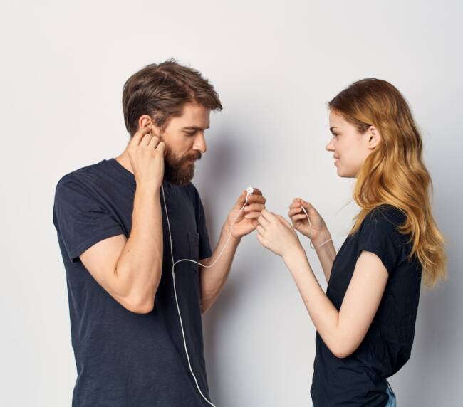 young couple in black t-shirts with headphones listening to music technology lifestyle. High quality photo