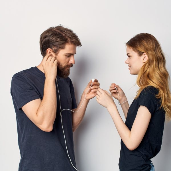 young couple in black t-shirts with headphones listening to music technology lifestyle young couple in black t-shirts with headphones listening to music technology lifestyle. High quality photo